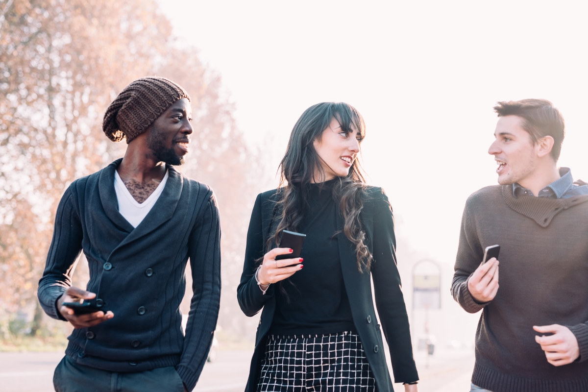 Three young people walking and talking